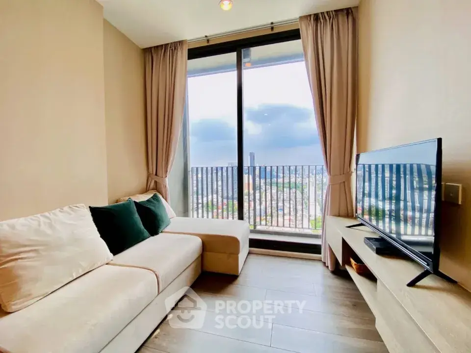 Modern living room with large window and city view, featuring cozy sofa and flat-screen TV.