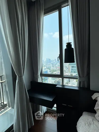 Modern bedroom with city view, featuring large windows and elegant curtains.