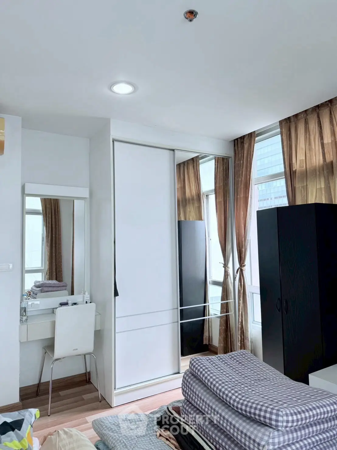 Modern bedroom with mirrored closet and natural light