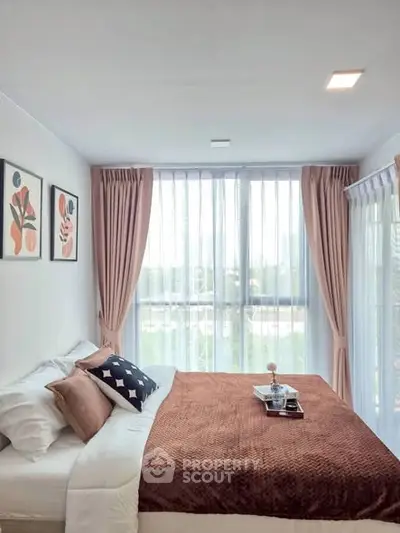 Bright and cozy bedroom with large windows and stylish decor.