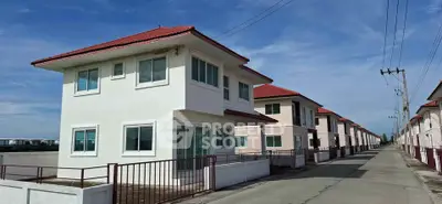 Modern suburban houses with red roofs and white facades in a peaceful neighborhood.