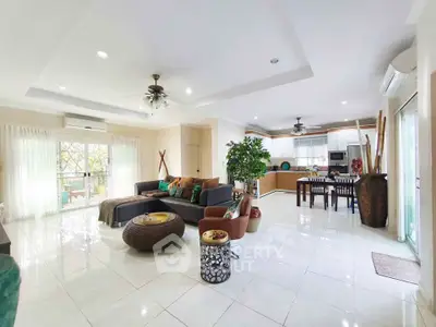 Spacious open-plan living room with modern kitchen and large windows