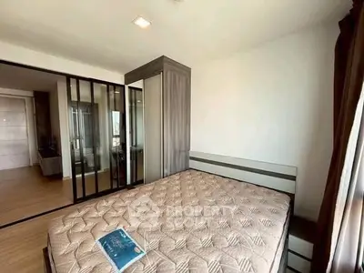 Spacious bedroom with large mirrored wardrobe and natural light