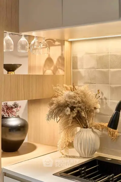 Modern kitchen with elegant decor and stylish lighting, featuring a sleek sink and decorative vases.