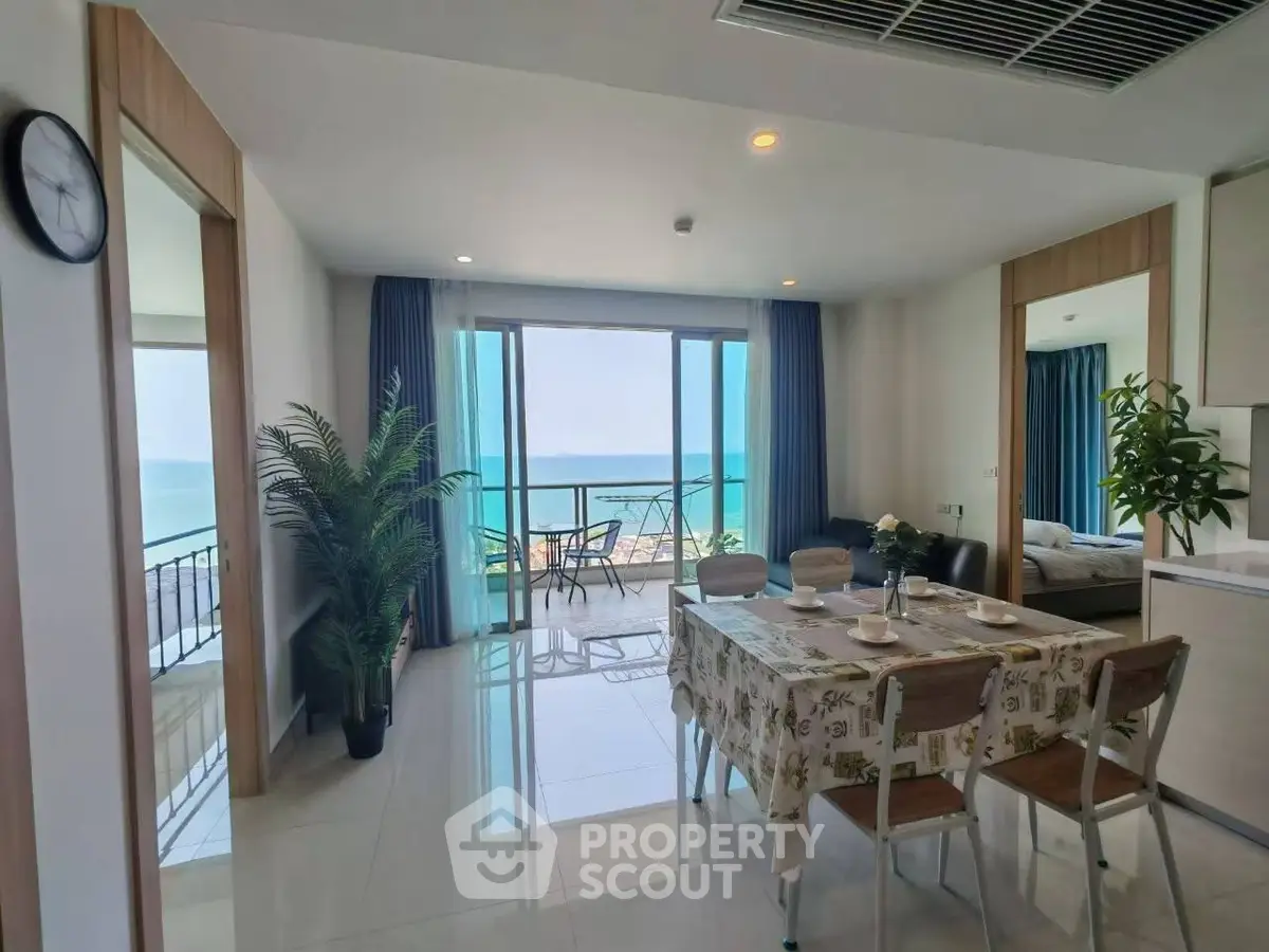 Stunning open-plan living room with ocean view and balcony access