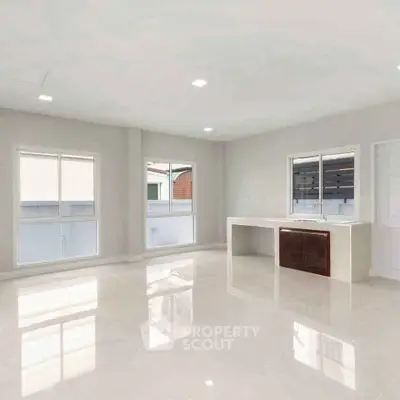 Spacious modern living room with large windows and sleek tile flooring