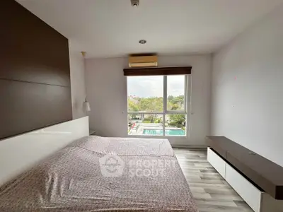 Spacious bedroom with large window offering a scenic view, modern furnishings, and ample natural light.