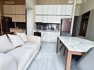 Modern open-plan kitchen and living area with sleek cabinetry and stylish furniture.