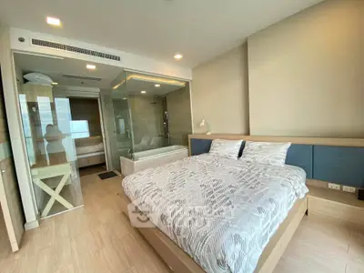 Modern bedroom with glass-enclosed bathroom and stylish decor