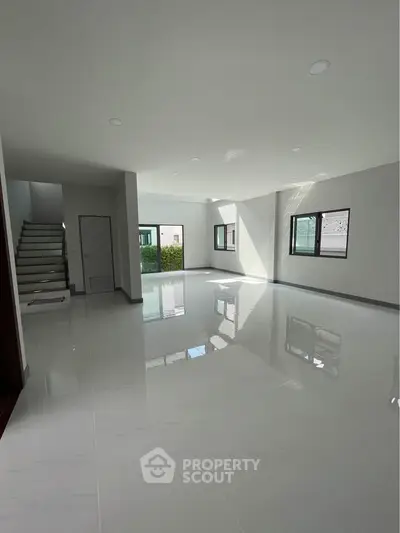 Spacious modern living room with glossy floors and ample natural light