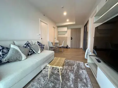 Modern living room with cozy sofa, stylish decor, and dining area in open layout.