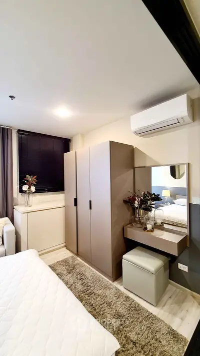 Modern bedroom with stylish decor and air conditioning, featuring a cozy bed and sleek wardrobe.