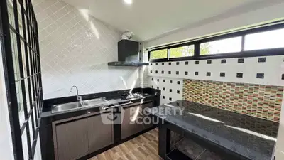 Modern kitchen with sleek black countertops and mosaic backsplash