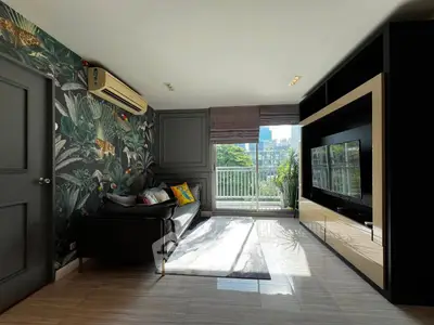 Stylish living room with modern decor and large window offering scenic views.