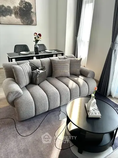 Stylish modern living room with plush sofa and elegant dining area, perfect for contemporary living.