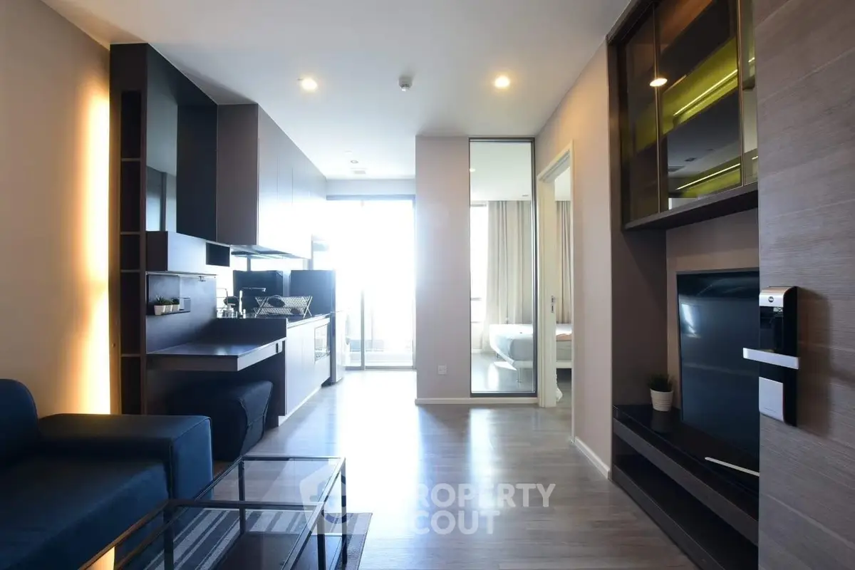 Modern open-plan living room with sleek kitchen and bright natural light