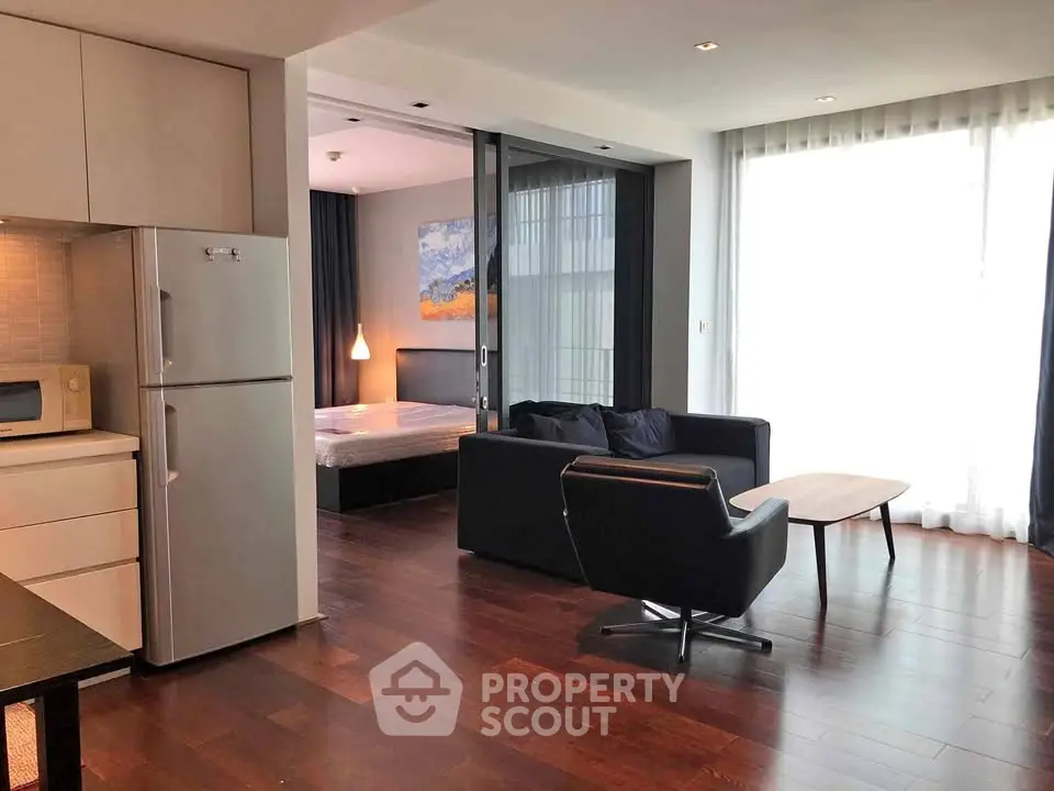 Modern open-plan living room with kitchen and bedroom in a stylish apartment.