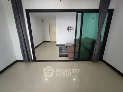 Spacious modern living room with sliding glass doors and sleek tile flooring