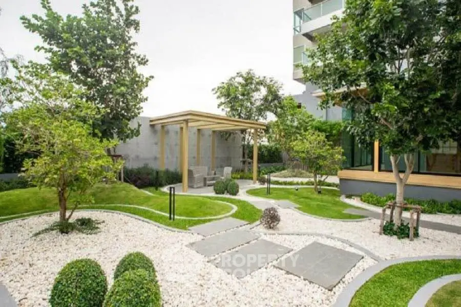 Luxurious garden area with modern landscaping and seating in upscale residential complex.