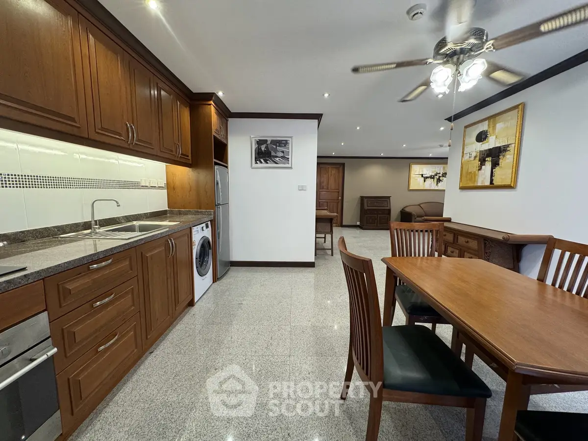 Spacious open-plan kitchen and dining area with wooden cabinetry and modern appliances.