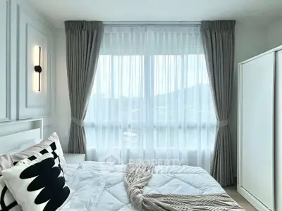 Bright and airy bedroom with large window and elegant curtains