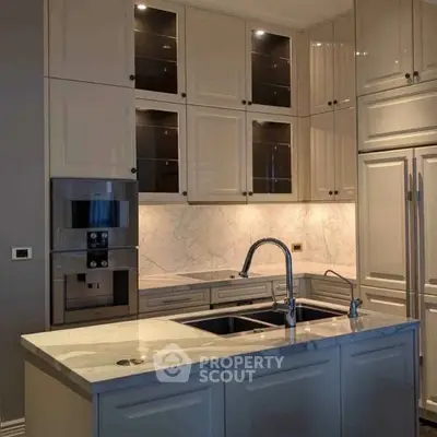Luxurious modern kitchen with marble countertops and high-end appliances.