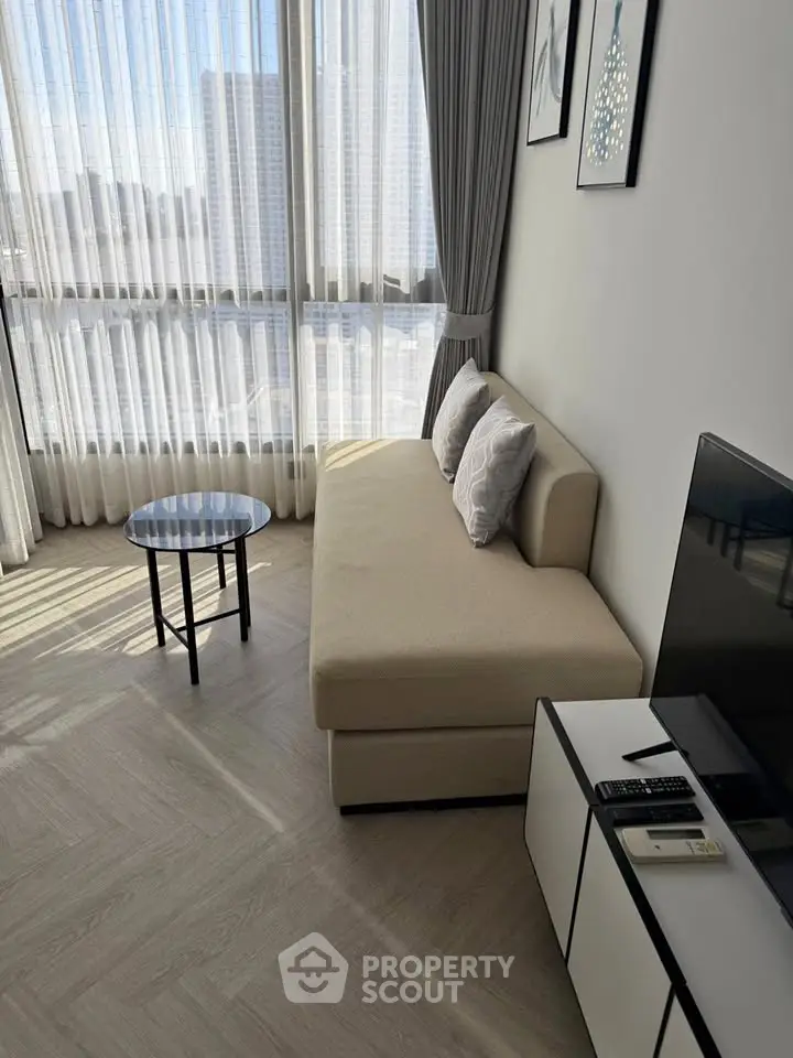 Modern living room with floor-to-ceiling windows and stylish furniture in a high-rise apartment.