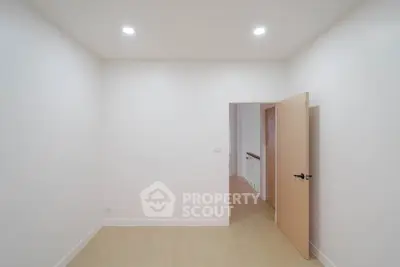 Spacious empty room with wooden door and bright lighting, ideal for customization.
