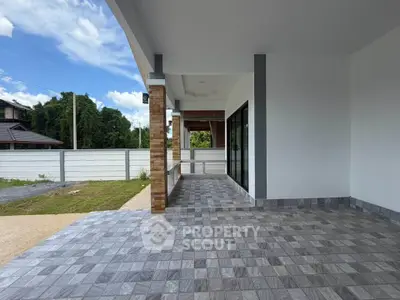Spacious covered patio with modern tile flooring and open view, perfect for outdoor relaxation.