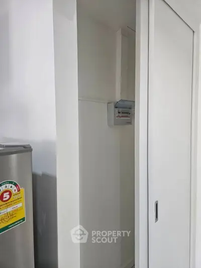 Compact storage area with sliding door and electrical panel, ideal for efficient space utilization.