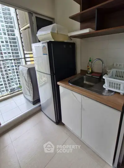 Compact kitchen with balcony view in modern apartment