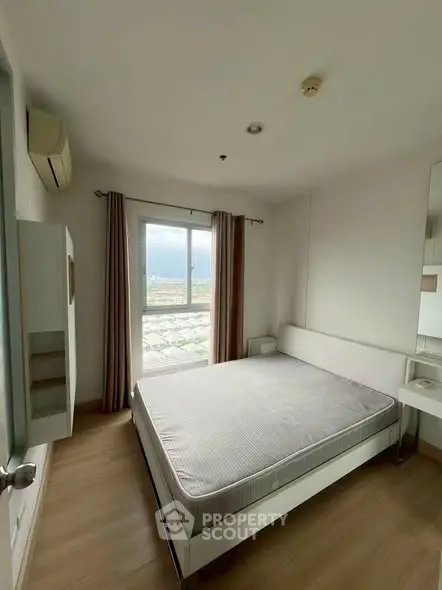 Modern bedroom with large window offering stunning city view, featuring minimalist decor and ample natural light.