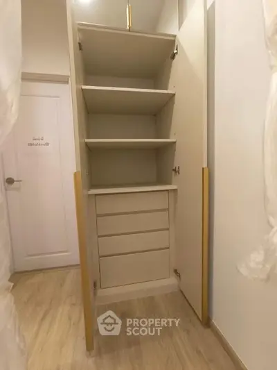 Spacious built-in storage cabinet with shelves and drawers in modern interior.