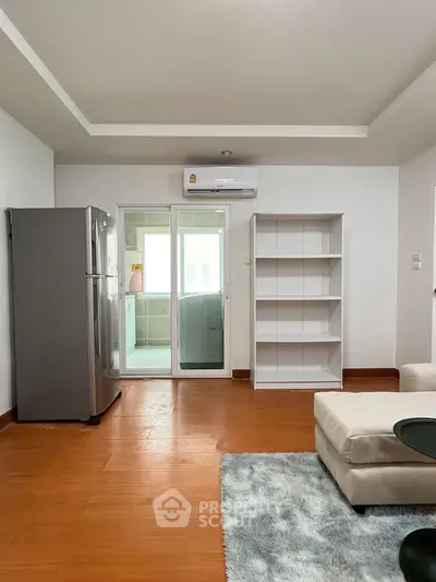Modern living room with sleek fridge and cozy seating area