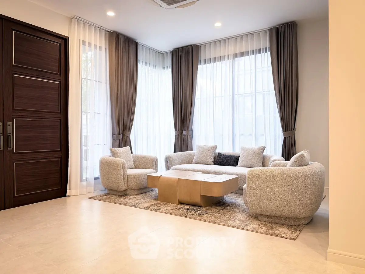 Elegant living room with modern furniture and large windows, perfect for relaxation and entertaining.