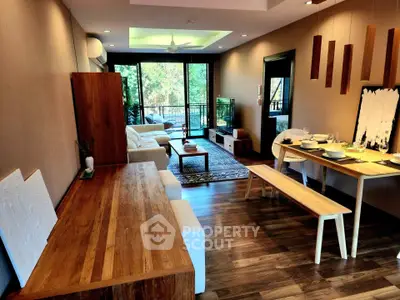 Spacious living room with modern wooden furniture and large windows opening to a balcony.