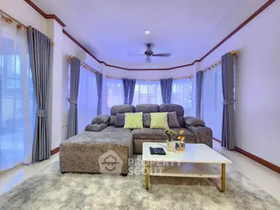 Spacious living room with plush gray sofa and elegant curtains