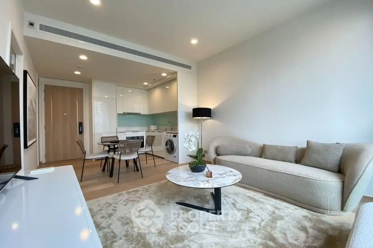 Modern living room with open kitchen, stylish furniture, and natural light