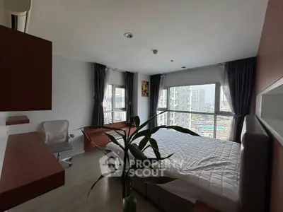 Spacious bedroom with large windows offering stunning city views, modern furnishings, and natural light.