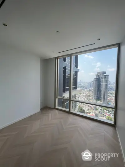 Spacious high-rise apartment with herringbone wood flooring and a large window offering a stunning cityscape view, ready for customization.