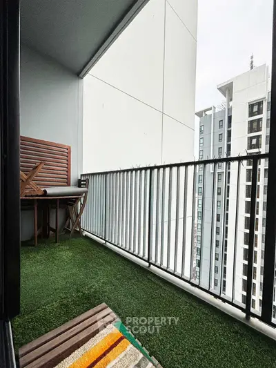 Modern balcony with artificial grass and city view in high-rise apartment
