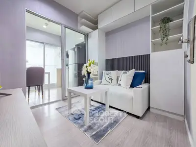 Modern living room with stylish decor and open layout leading to balcony.