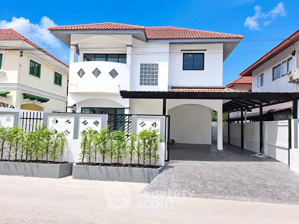 Charming two-story house with red-tiled roof and spacious driveway in a serene neighborhood.