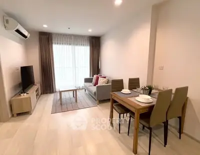 Modern living room with dining area, featuring sleek furniture and natural light.