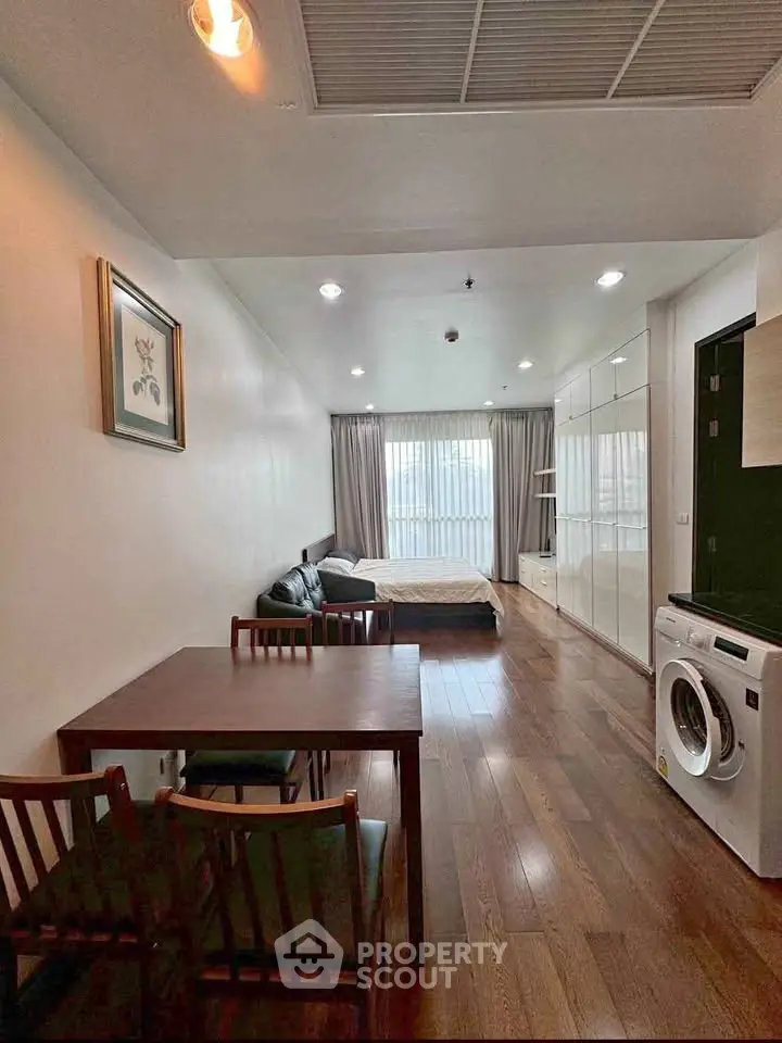 Modern studio apartment with wooden flooring and washing machine