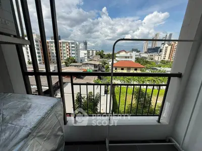 Urban balcony view with cityscape and greenery, perfect for relaxation and enjoying the skyline.
