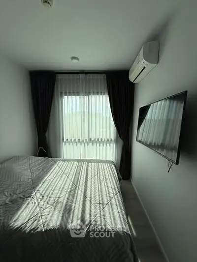 Cozy bedroom with modern air conditioning and large window for natural light.