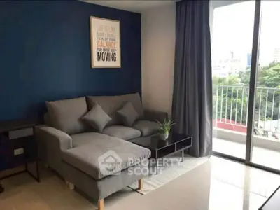 Modern living room with stylish gray sofa and balcony view, perfect for urban living.