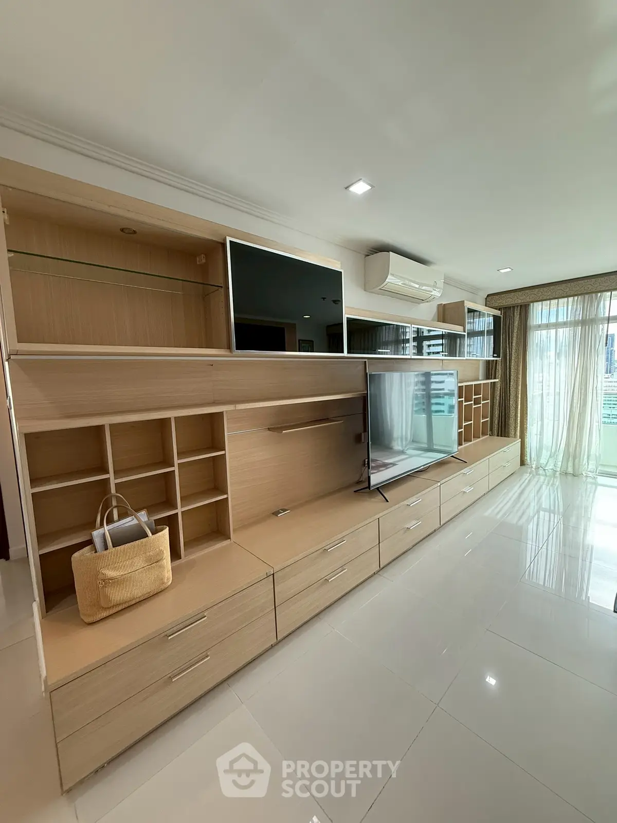 Spacious modern living room with built-in storage and large windows for natural light.