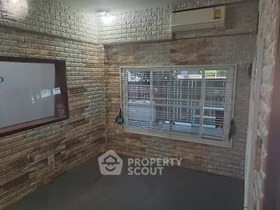 Cozy room with brick walls and air conditioning, perfect for a home office or study.